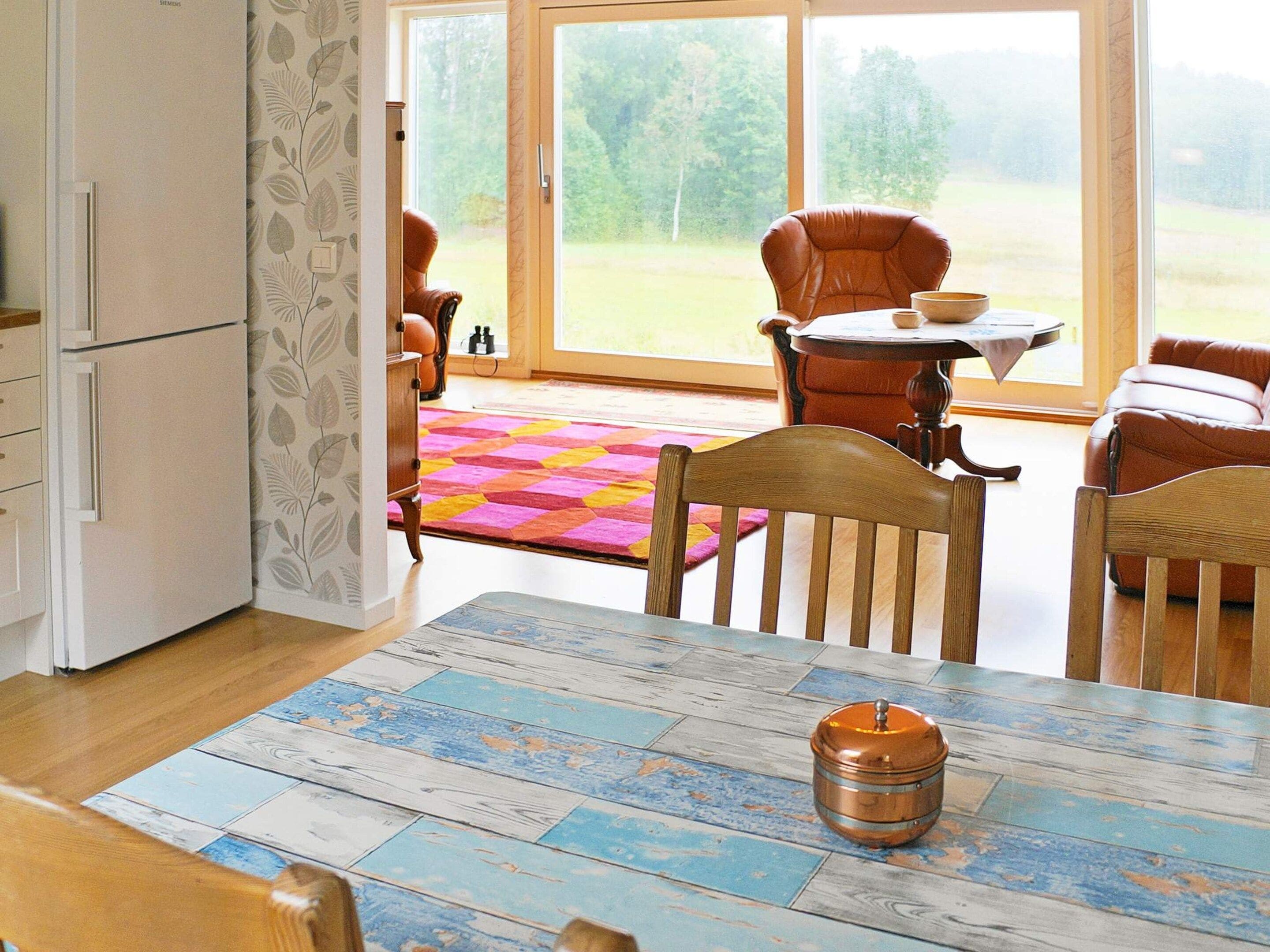 A dining area with a table, chairs, and a view of the outdoors.