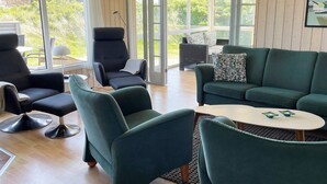 Una sala de estar moderna con un sofá, sillones y una mesa de centro.