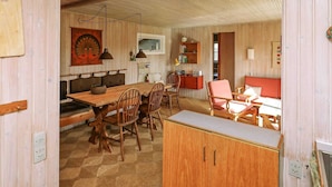 A cozy, rustic interior with a wooden dining table, chairs, a sofa, and a cabinet. - 5 Person Holiday Home in Ringkobing-by Traum (Ringkobing)