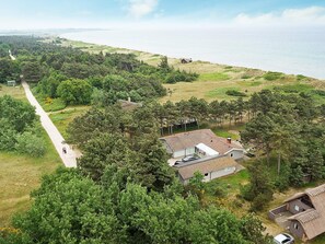 A coastal property with a paved driveway, multiple buildings, and a view of the sea. - 16 Person Holiday Home in Humble (Sydlangeland)