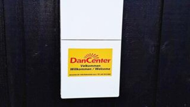 A white sign with a yellow label that reads 'DanCenter Welcome.' - 4 Star Holiday Home in Tarm (Tarm)