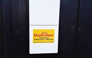 Un panneau blanc avec une étiquette jaune sur laquelle on peut lire : « Bienvenue chez DanCenter. »