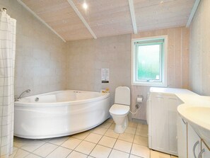A bathroom with a bathtub, toilet, and sink.