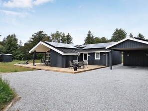 Un bâtiment moderne doté d’un patio couvert, d’un garage et d’une plaque portant le numéro 16.