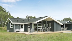 A modern house with a covered patio, large windows, and outdoor seating. - 5 Star Holiday Home in Albaek (Aalbaek)