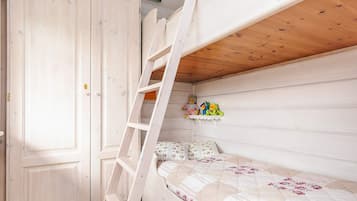A bunk bed with a ladder, a wooden door, and a shelf with plush toys.