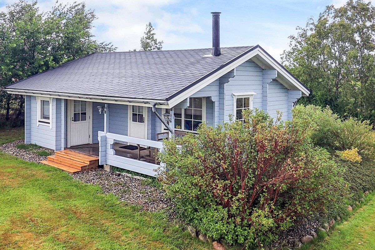 A single-story house with a gabled roof, a front porch, and a chimney.