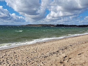 A beach with a sandy shore and a view of the sea.