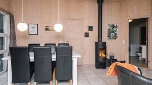 Moderni sisustus, jossa on ruokailutila, puupaneloitu seinä, takka ja pyykinpesutila.