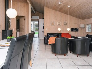 Ein modernes Interieur mit einer Essecke, einem schwarzen Ledersofa und einem Kamin.