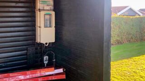 A utility meter attached to a building's exterior wall.