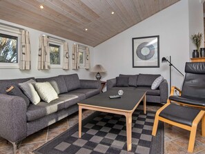 A modern living room with two grey sofas, a black coffee table, a wooden floor, and a framed abstract artwork on the wall. - 4 Star Holiday Home in Hemmet (Hemmet)