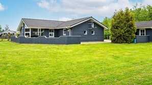 Il s’agit d’une propriété résidentielle dotée d’une cour clôturée et d’une maison avec un toit en pente et de nombreuses fenêtres.