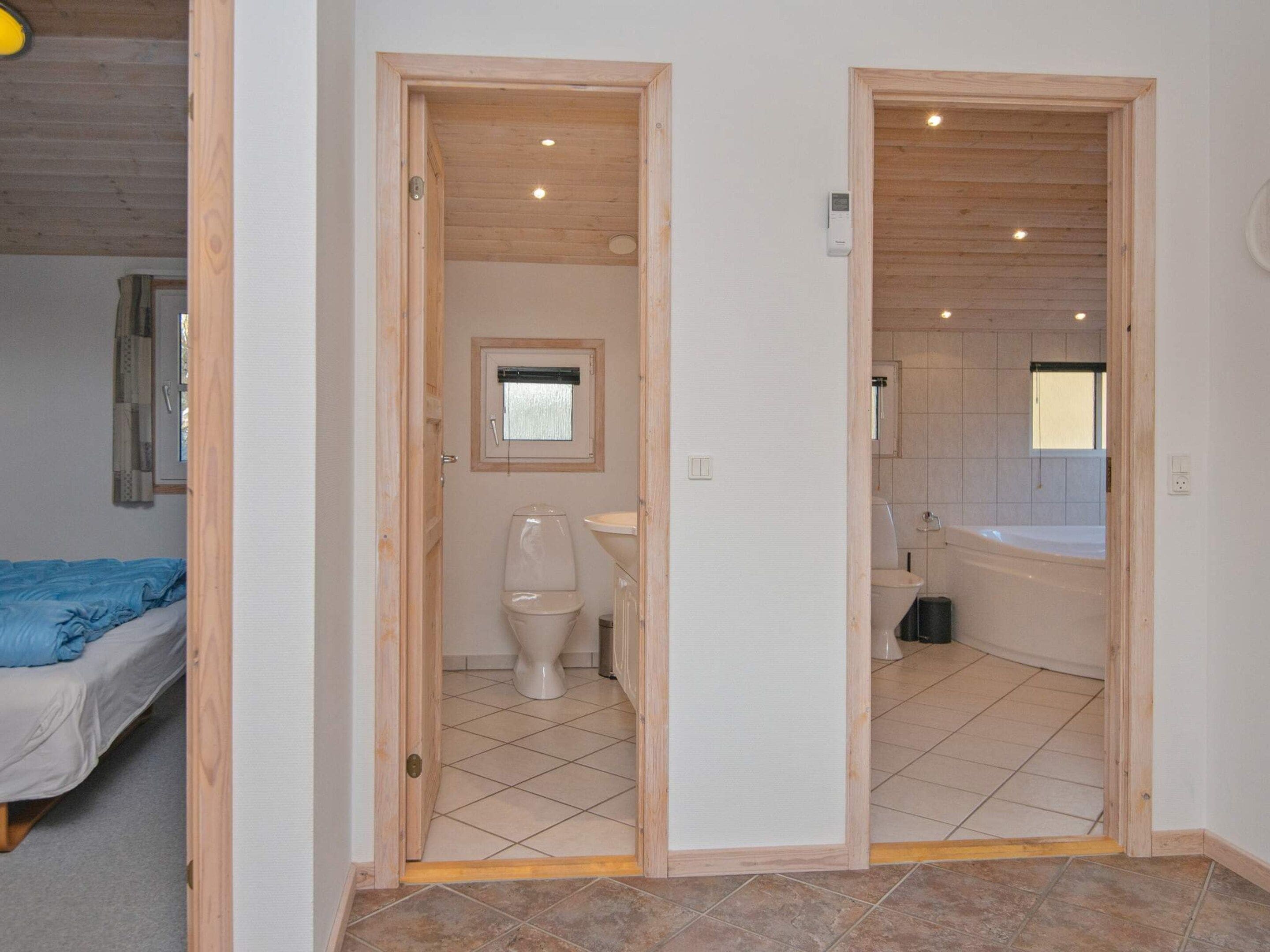 Una habitación con cama, inodoro y zona de ducha.