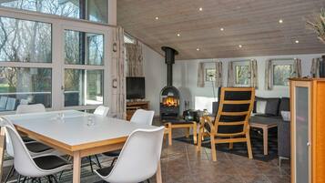 Een modern interieur met een eethoek, een open haard en een bank.