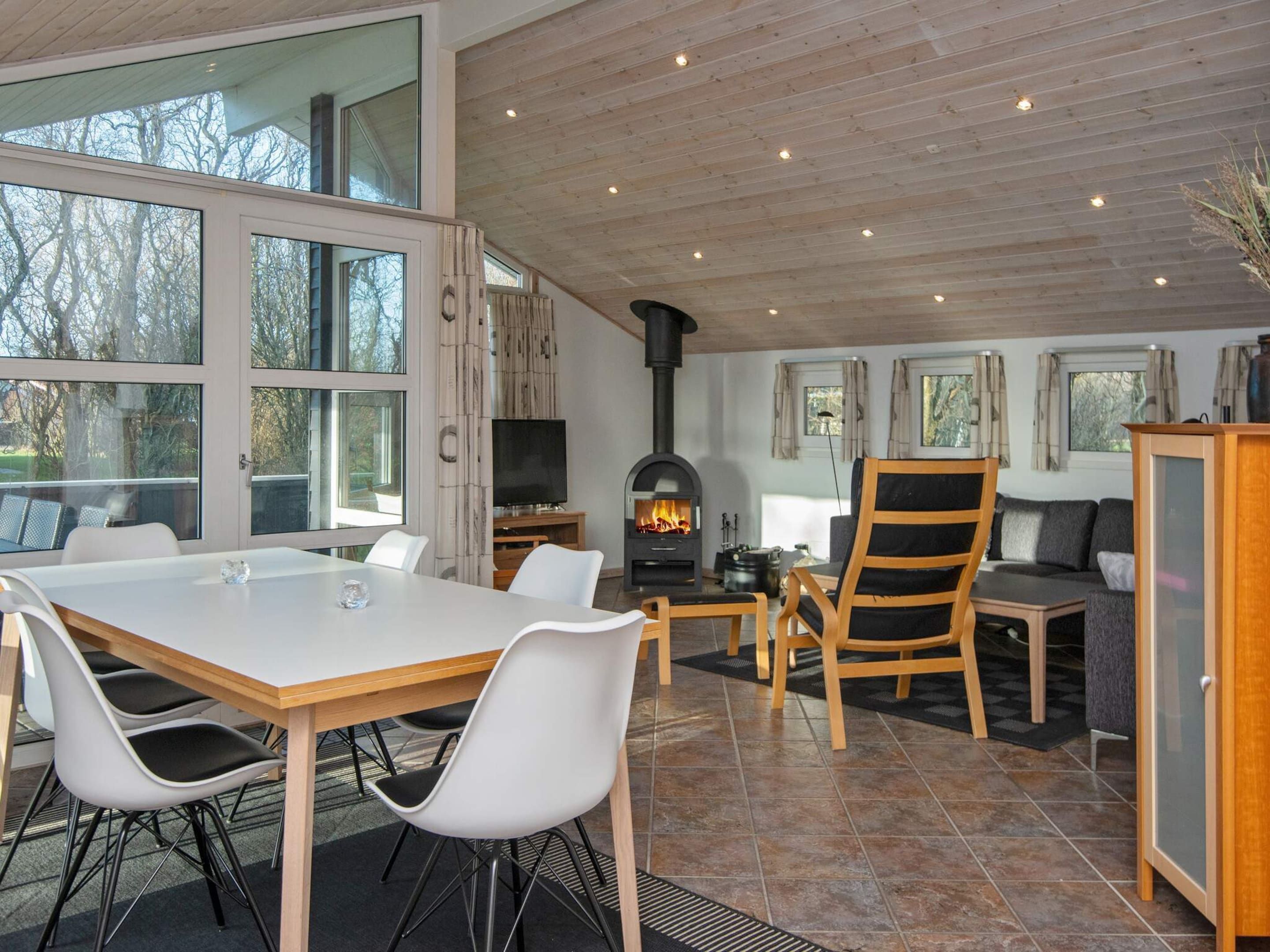 A modern interior with a dining area, a fireplace, and a sofa.