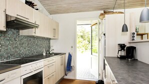 A modern kitchen with a gas stove, oven, and a tiled backsplash. - Spacious Holiday Home in Højslev near Sea (Hojslev)