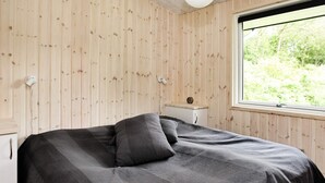 A room with a bed, a nightstand, a window, and a ceiling light. - Spacious Holiday Home in Højslev near Sea (Hojslev)