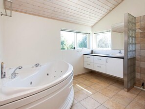 Ein modernes Badezimmer mit einer freistehenden Badewanne, einem Doppelwaschtisch und einem großen Spiegel.
