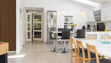 A modern kitchen with a central island, stainless steel appliances, and pendant lighting.