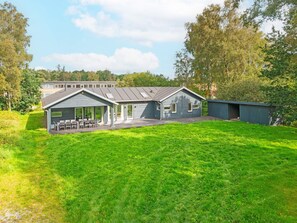 A residential property with a covered patio, a detached garage, and a well-maintained lawn.