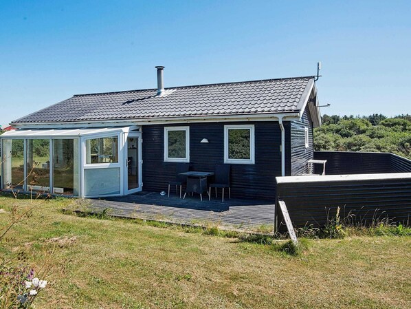 A house with a covered patio, a chimney, and a small deck.