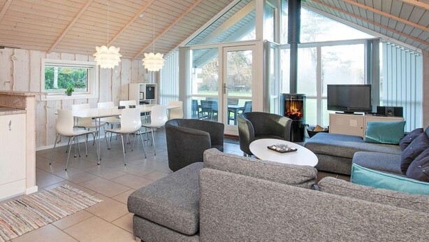 A spacious living area with a high ceiling, a fireplace, and a television. - 8 Person Holiday Home in Humble (Sydlangeland)