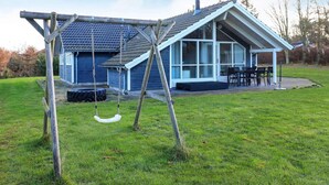 A house with a porch, a swing set, and a dining area. - 8 Person Holiday Home in Humble (Sydlangeland)