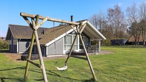 A wooden swing set in a grassy yard with a house in the background. - 8 Person Holiday Home in Humble (Sydlangeland)