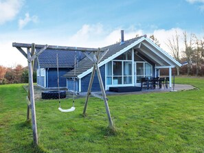 A house with a porch, a swing set, and a dining area. - 8 Person Holiday Home in Humble (Sydlangeland)