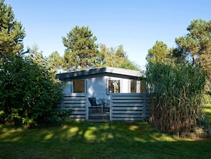 A small cabin with a deck, surrounded by trees and vegetation. - 4 Person Holiday Home in Ebeltoft-by Traum (Ebeltoft)