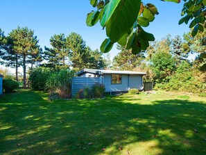 Situated in a serene natural setting, this cabin offers a peaceful retreat surrounded by lush vegetation and well-maintained grounds.