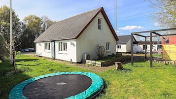 A house with a white exterior, a sloped roof, and a small front yard.