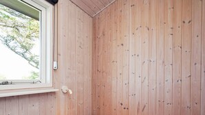 A room with a single bed, a window, and wooden walls. - 4 Star Holiday Home in Struer (Struer)
