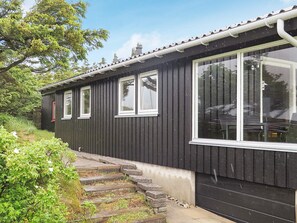 A black building with a windowed side and a set of stone steps leading up to it. - 4 Star Holiday Home in Struer (Struer)