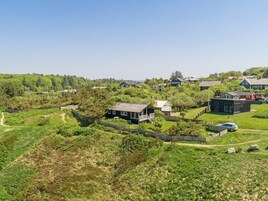 A residential area with houses surrounded by greenery and a clear sky.