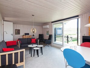 Un salon moderne comprenant un canapé, des fauteuils, une table à manger et un balcon avec vue.