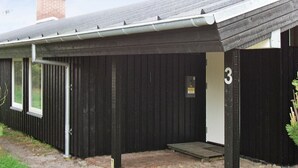 A black metal building with a number '3' sign, a door, and a small ramp leading to a covered entrance. - Spacious Holiday Home in Oksbol near Sea (Oksbol)