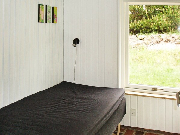 A single bed in a room with a window.
