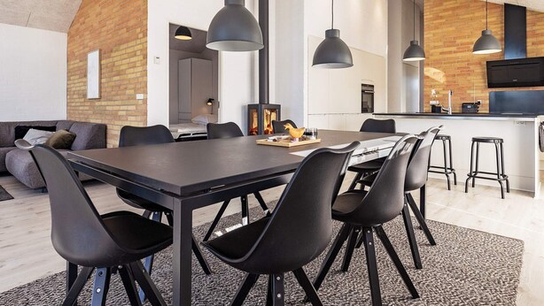 A modern kitchen with a central island, black chairs, and pendant lighting. - 6 Person Holiday Home in Otterup-by Traum (Otterup)
