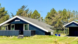 A blue cabin with a sign reading 'GIVAS' and a picnic table outside. - 4 Star Holiday Home in Blavand (Blavand)