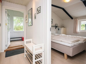 A cozy room with a bed, a desk, and a window overlooking greenery.