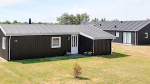 A modern, single-story building with a dark exterior and a sloped roof.