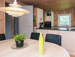 Eine moderne Küche mit Holzausstattung, einem eingebauten Backofen und einer Kaffeemaschine.