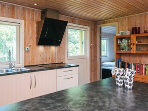 Eine moderne Küche mit Holzwänden, einer schwarzen Arbeitsplatte und einem eingebauten Backofen.