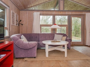 A cozy room with a purple sofa, a small white table, and a red cabinet.