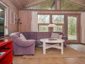 A room with a purple sofa, a white coffee table, and a red cabinet. - 6 Person Holiday Home in Glesborg (Glesborg)