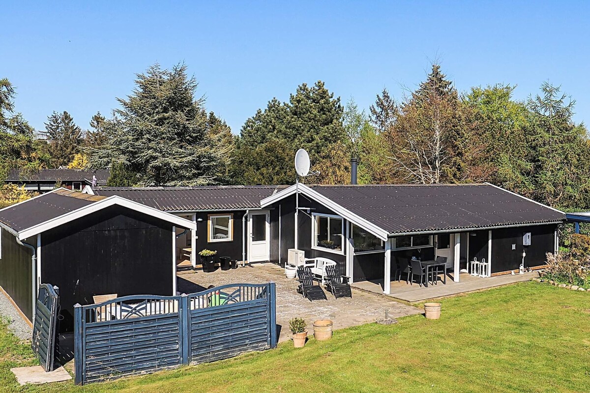 A two-story building with a covered patio area, a fenced yard, and a satellite dish.