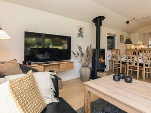 A living room with a TV, sofa, table, and a fireplace.