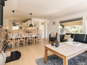 A modern living room with a dining area, a sofa, and a coffee table.